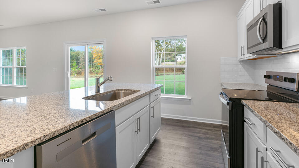73 Stone Apiary Drive Angier, NC 27501 - Photo 8 of 32 a kitchen with granite countertop a sink and a stove