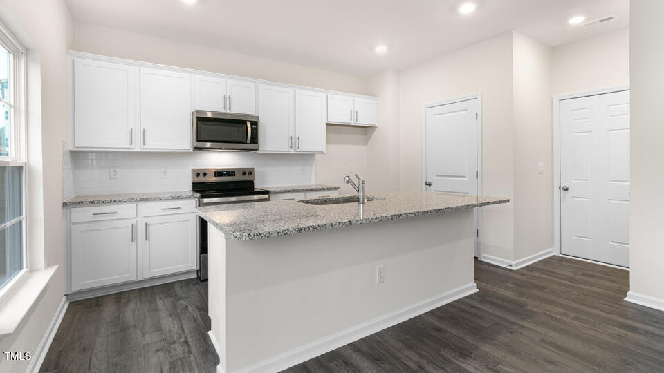73 Stone Apiary Drive Angier, NC 27501 - Photo 10 of 32 a kitchen with granite countertop white cabinets and stainless steel appliances