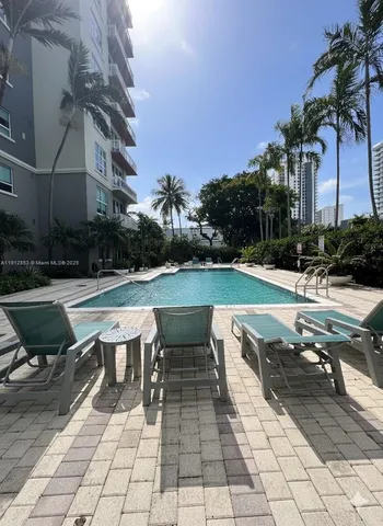 a view of a swimming pool with lounge chair in the patio