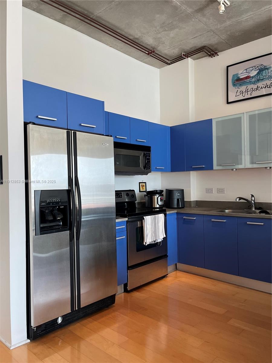 313 Northeast 2nd Street, Unit 802 Fort Lauderdale, FL 33301 - Photo 7 of 12 a kitchen with stainless steel appliances granite countertop a refrigerator a stove and a sink