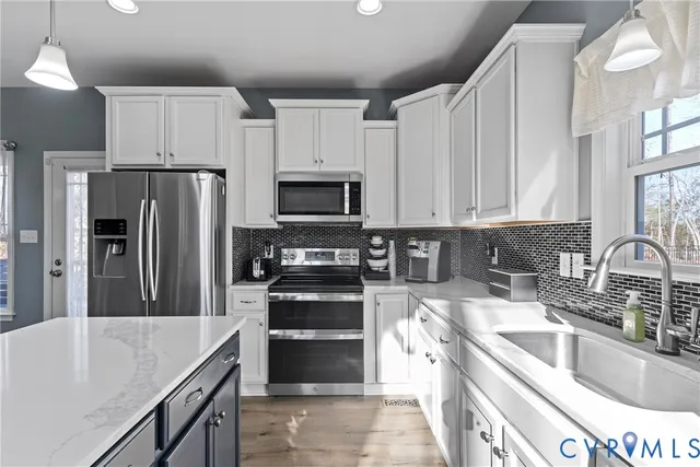 a kitchen with kitchen island a sink stove and refrigerator