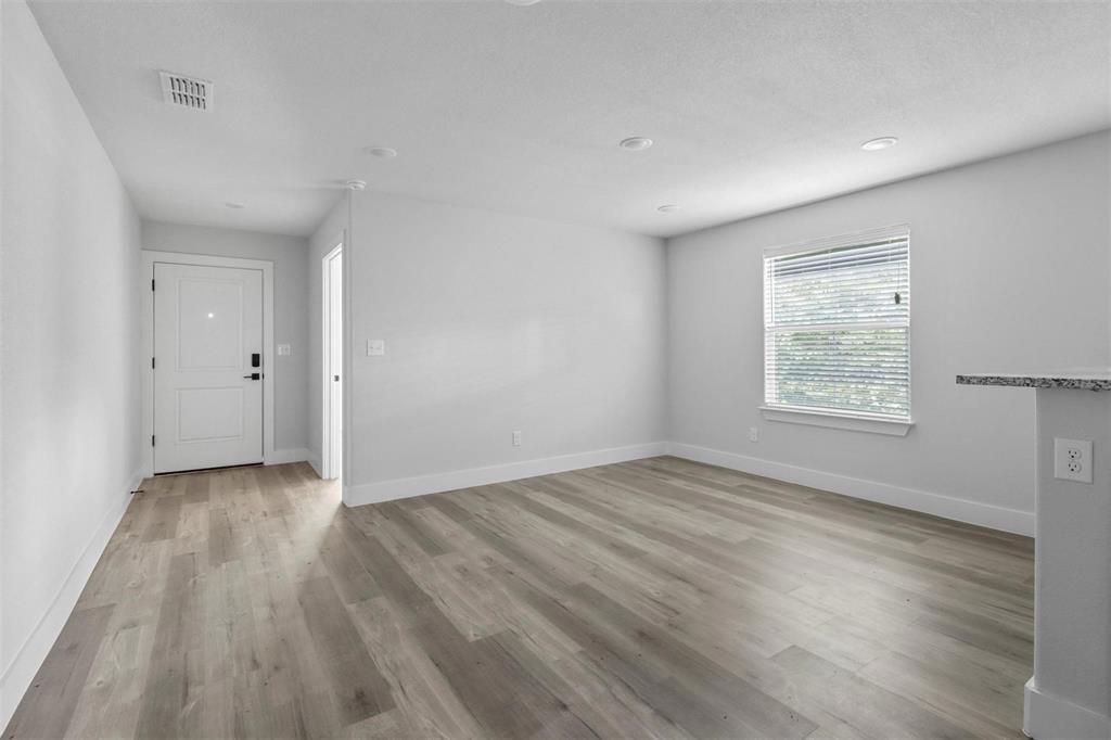 408 West 6th Street, Unit 2 Bonham, TX 75418 - Photo 6 of 16 an empty room with wooden floor and windows