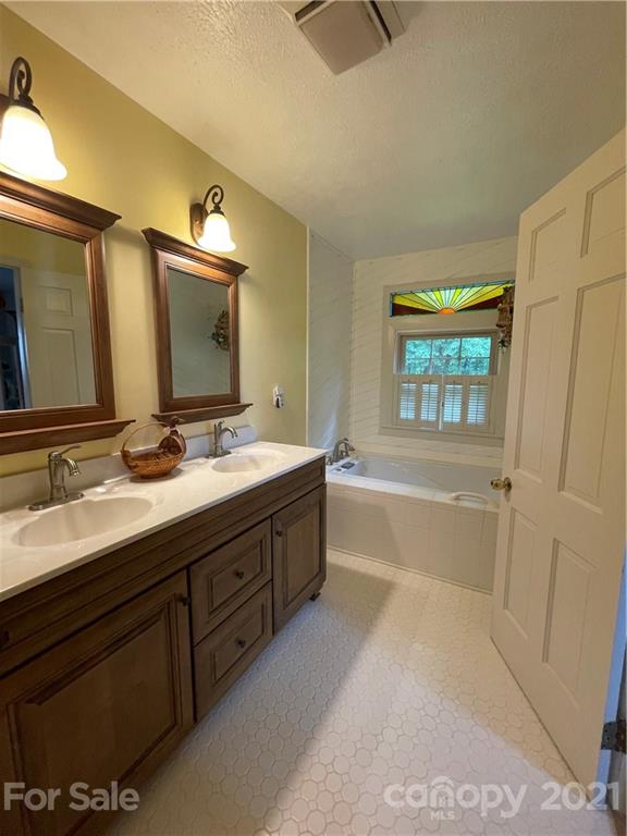 44 Emerald Mountain Road Clyde, NC 28721 - Photo 18 of 33 a bathroom with a tub sink and mirror