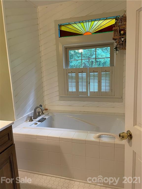44 Emerald Mountain Road Clyde, NC 28721 - Photo 19 of 33 a bathroom with a bathtub and a window