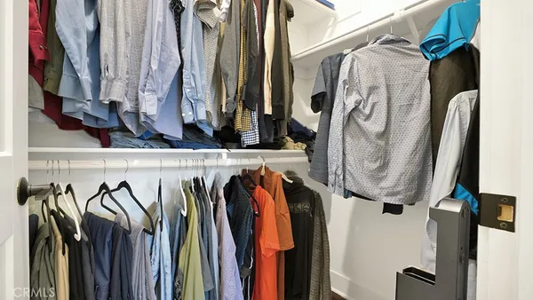 a view of walk in closet with clothes and shoes