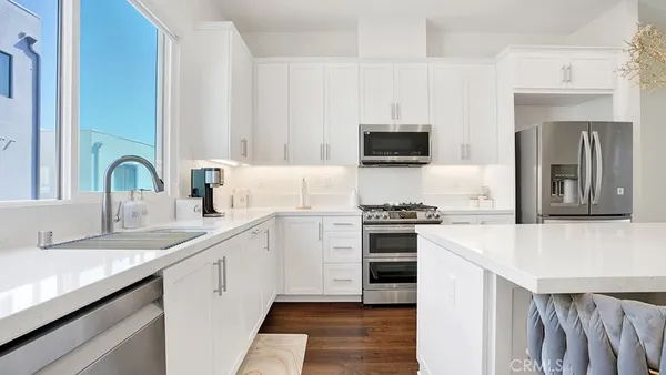 a kitchen with stainless steel appliances granite countertop a sink a stove and wooden cabinets