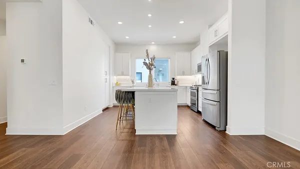 a kitchen with stainless steel appliances kitchen island granite countertop a refrigerator and a stove top oven