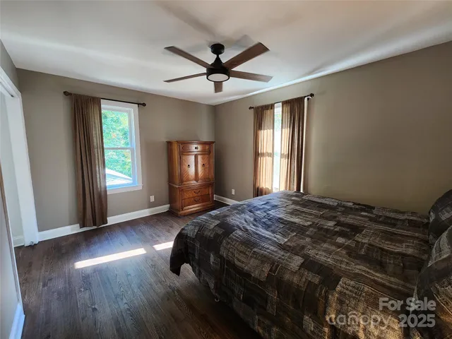 a bed sitting in a spacious bedroom next to a window