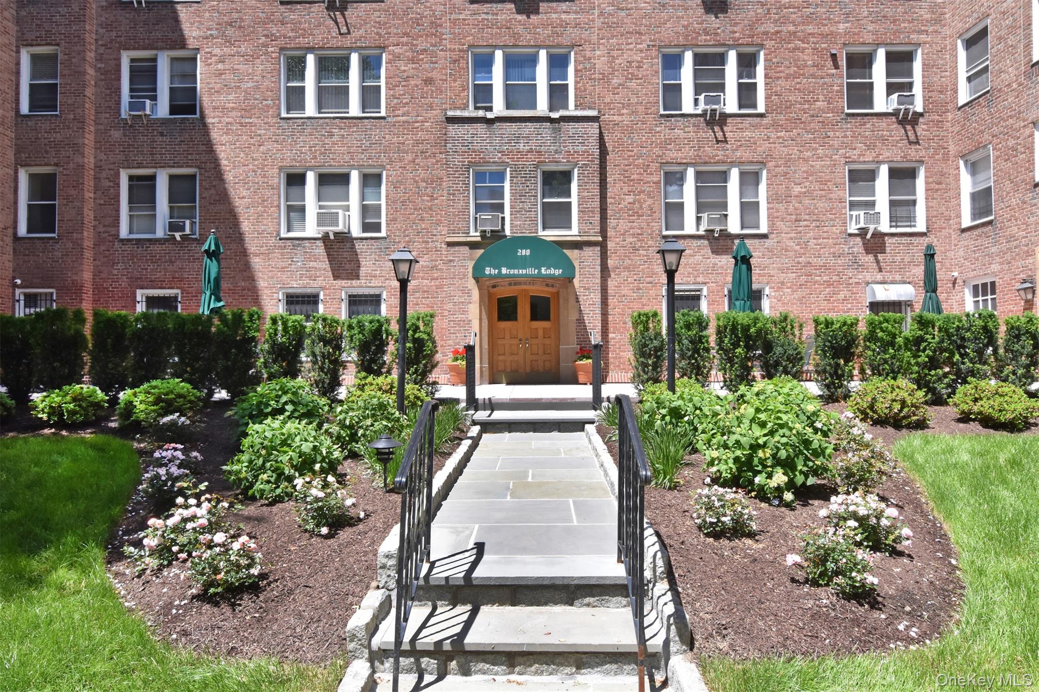 280 Bronxville Road, Unit 5W Bronxville, NY 10708 - Photo 12 of 14 At the rear of the building, a secondary entrance opens to a beautifully landscaped courtyard and well-maintained grounds.