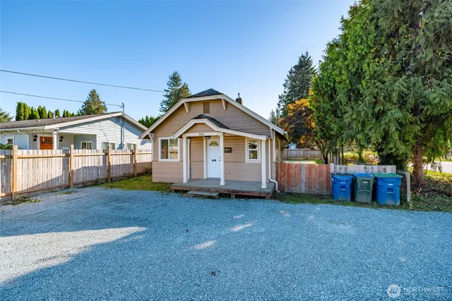a front view of a house with a yard and trees