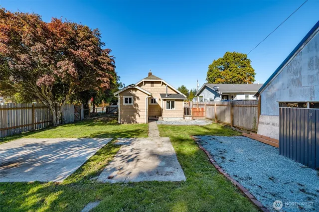 a view of a back yard with flower plants and wooden fence