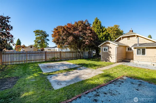 a view of a house with backyard and trees
