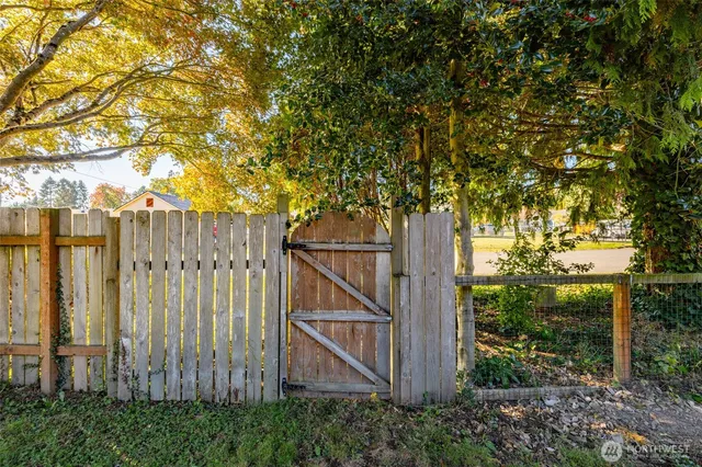 a view of a wooden fence next to a large tree