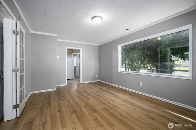 a view of empty room with wooden floor and fan