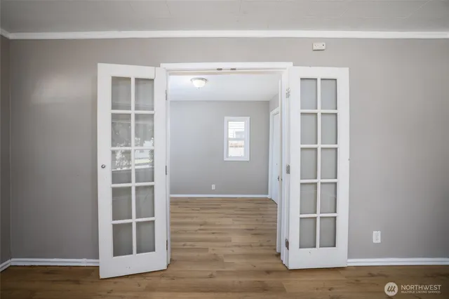 a view of a hallway with wooden floor and cabinet