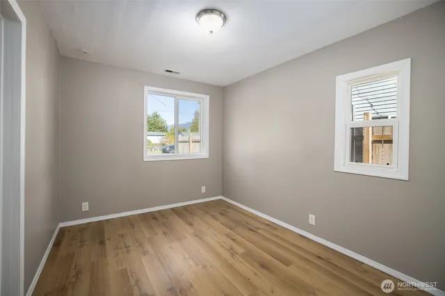 a view of room with window and wooden floor