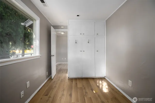 a view of a hallway with wooden floor and a window