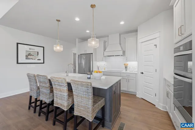 a kitchen with kitchen island white cabinets and stainless steel appliances