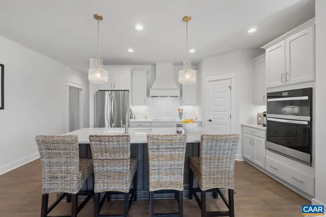 a kitchen with kitchen island white cabinets and stainless steel appliances