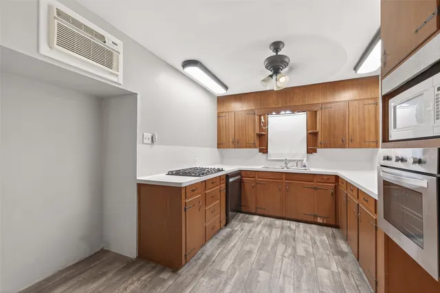a kitchen with a stove sink and cabinets