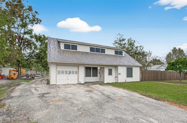 a front view of house with yard and trees around