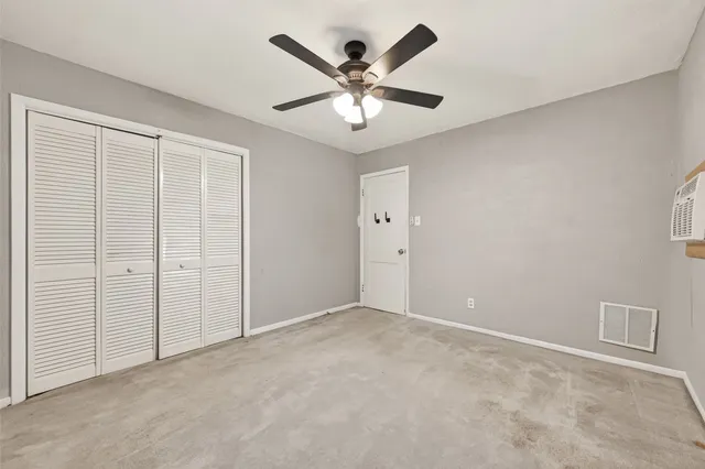 an empty room with closet and ceiling fan