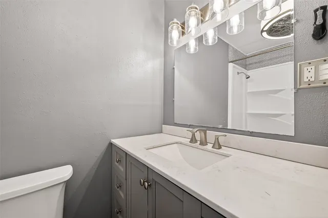 a bathroom with a sink a toilet and a mirror