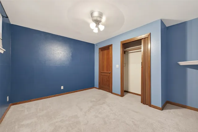 an empty room with a ceiling fan and a window