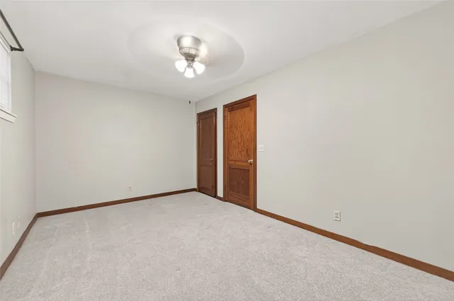 an empty room with a chandelier fan