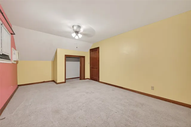 an empty room with a ceiling fan and window