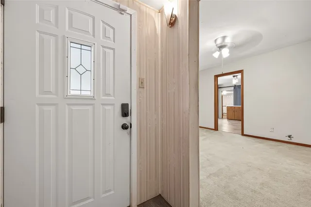 a view of an empty room with closet and a mirror