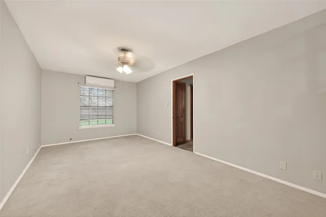 an empty room with windows and chandelier fan