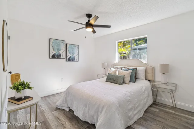 a bedroom with a bed and wooden floor