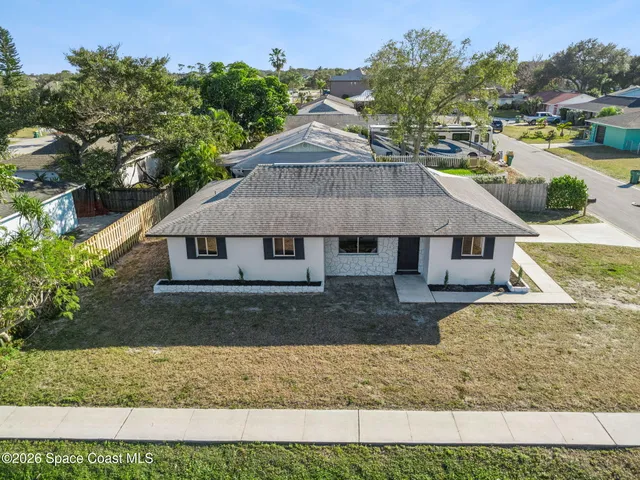 a aerial view of a house next to a yard