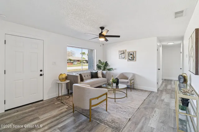 a living room with furniture a chandelier and a window