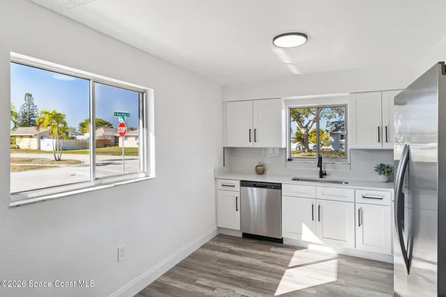 a kitchen with stainless steel appliances a sink a stove a refrigerator a counter top space and a window