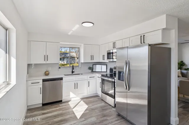 a kitchen with white cabinets and stainless steel appliances