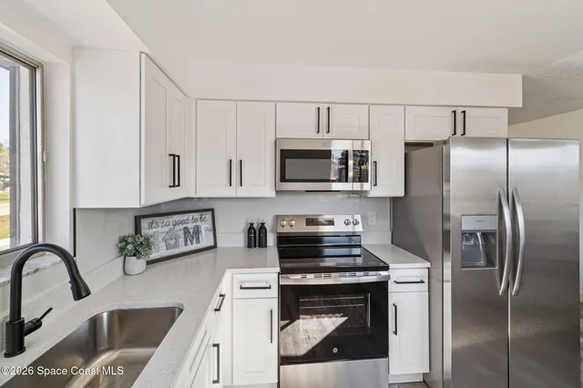a kitchen with stainless steel appliances granite countertop a refrigerator a stove top oven a sink and dishwasher