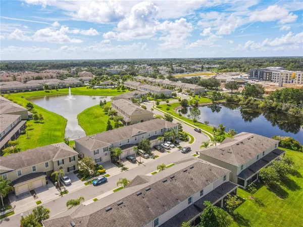an aerial view of residential houses with outdoor space and lake view