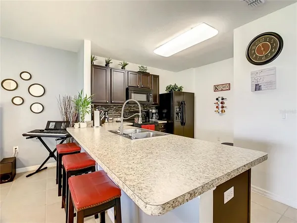a kitchen with stainless steel appliances kitchen island granite countertop a refrigerator stove and sink