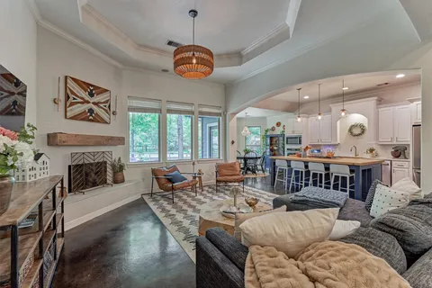 a living room with furniture fireplace and a large window