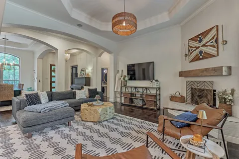 a living room with furniture a flat screen tv and kitchen view