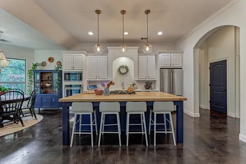 a large kitchen with a table and chairs