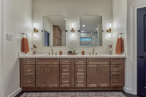 a bathroom with a double vanity sink a mirror and a shower