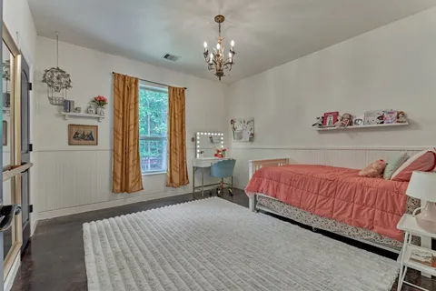 a bedroom with a bed a dresser and chair