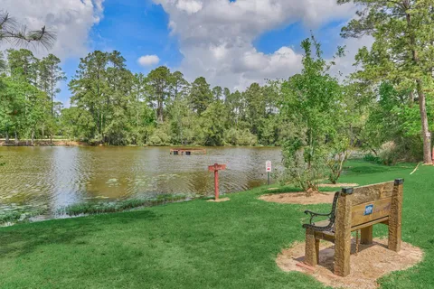 a backyard of a house with lots of green space and lake view