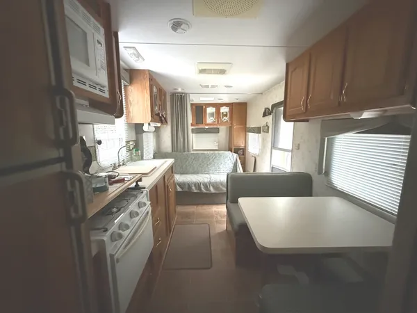 a living room with stainless steel appliances granite countertop furniture and a kitchen view