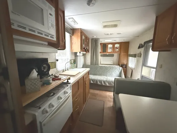 a living room with stainless steel appliances granite countertop furniture a fireplace and a large window