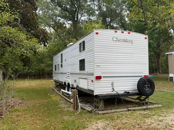 a backyard of a house with barbeque oven and wooden fence