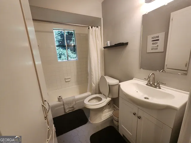 a bathroom with a sink toilet and a mirror